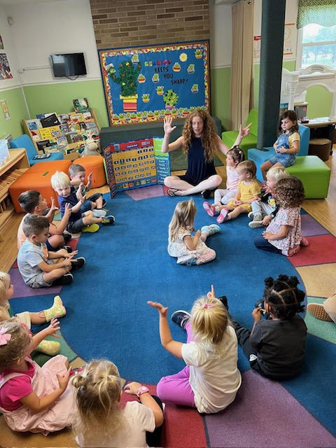 Group of children participating in Circle Time with their teacher Ms. Lisa