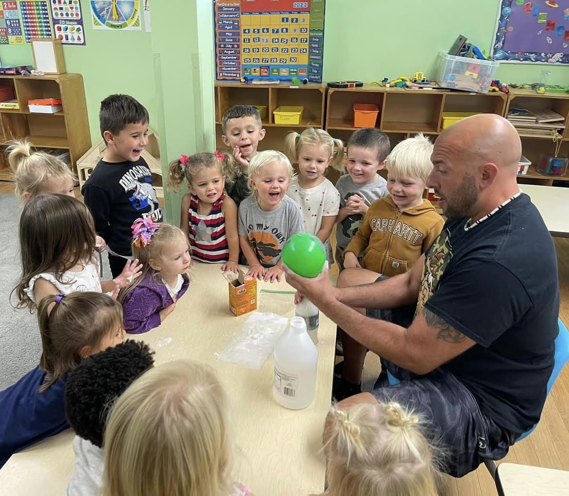 Children doing a science experiment with their teacher Mr. Sam